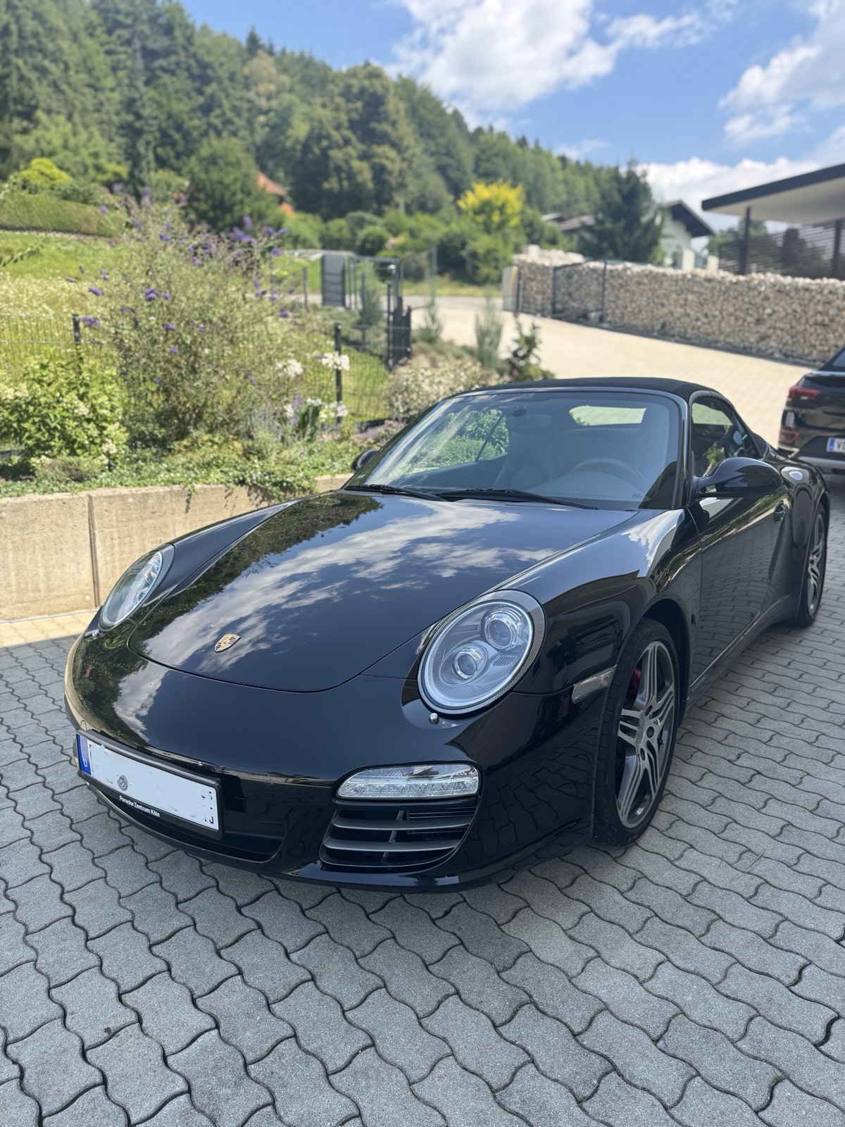 Porsche 911 Carrera 4S Cabriolet in Basaltschwarz, Frontansicht am Hang